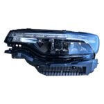 Grand Commander K8 headlight assembly with a segmented upper strip, broad reflective chambers and a ribbed lower housing